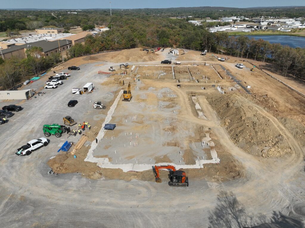 Aerial view of the new clinic site in September 2026, with the white outline of the building footings visible on the prepared pad.